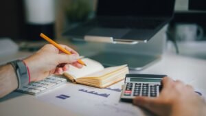 Person at a desk with a calculator and notebook working out 2027 tax estimates