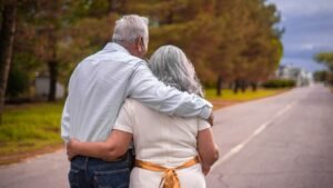 Older couple walking arm in arm down a road, representing retirement planning